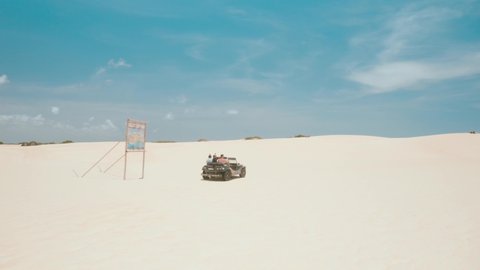 Beach-buggy with its tourist passengers races along the dunes at Genipabu near Natal, northeast Brazil