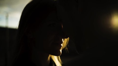 Silhouettes of loving couple heads close to each other in sunset. Action. Close up of romantic male and female unrecognizable faces hidden in the shadow with golden sunlight.