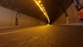 Time lapse night video of tunnel taken by stabilised camera attached to motorcycle as seen from lowest possible asphalt perspective 