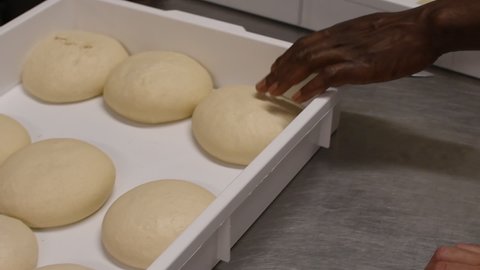 Pizzaiolo chef checks the balls of pizza dough