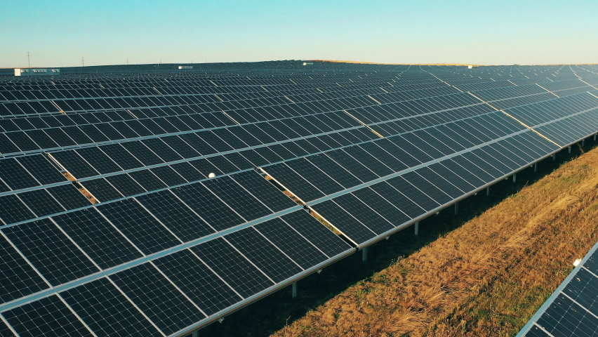 Aerial shot of three solar energy engineers on a large solar farm Royalty-Free Stock Footage #1064128603
