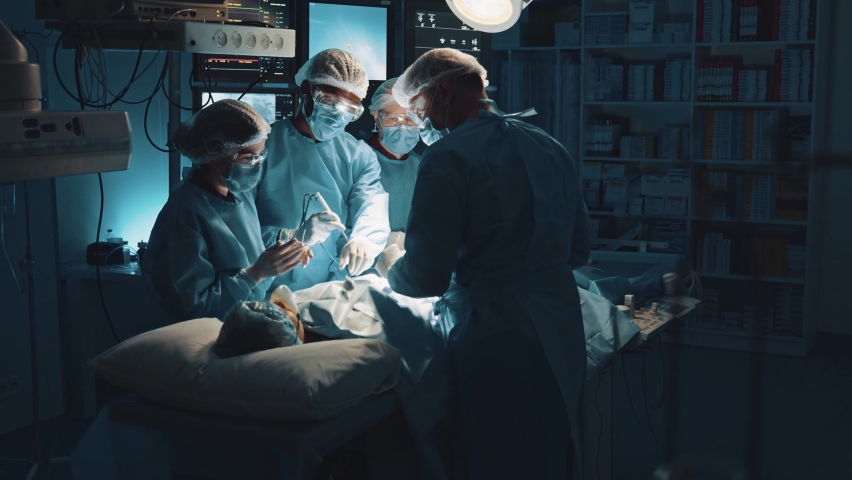 Multi-ethnic cooperating team of doctors and surgeons processing surgical operation in operating room modern hospital emergency department. Heart surgery. | Shutterstock HD Video #1064130013