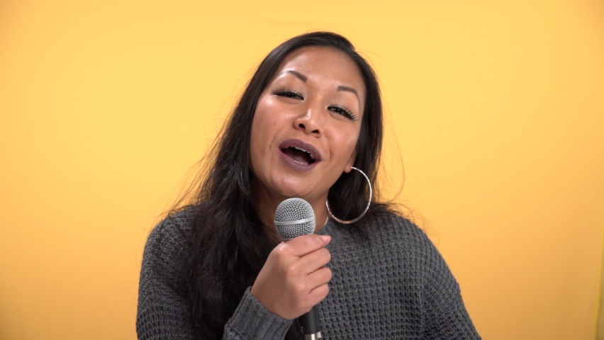 Alluring woman sings into microphone with energy in slow motion