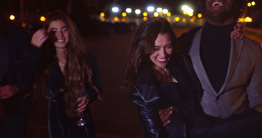 Friend carrying drunk girl at night on the streets