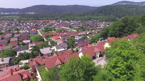 AERIAL: Flying above luxury suburban rooftops of homes in the middle of the lush forest