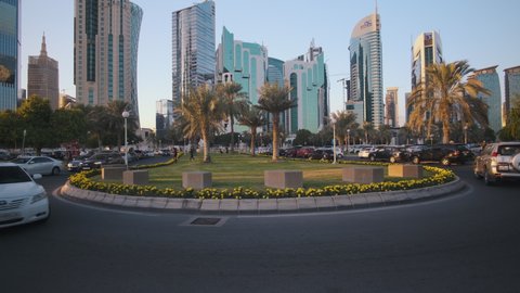 Doha, Qatar-December 13 2020:Sheraton park afternoon zooming in shot with cars and people in the street  and Doha skyline  in background