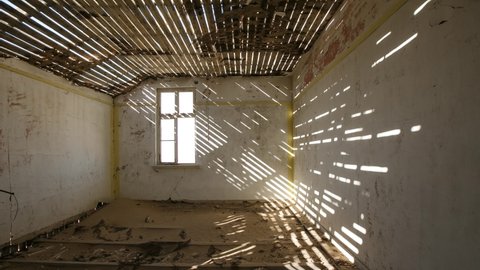 The abandoned diamond mining town of Kolmanskop in Namibia. Time Lapse of an abandoned room of a house. The shadows move across the room at the sun changes position in the sky.