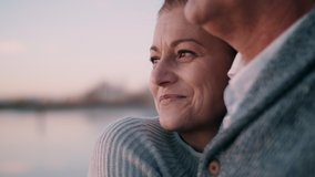 Man and woman hugging each other by the water and watching the sunset - Powered by Shutterstock - Get 15% off with code: PIKWIZARD15