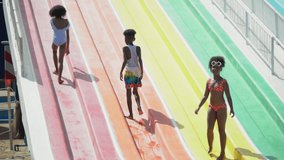 group of happy african american kid runing and jumping on dry waterslide to swiming pool at water park together in summer holidays Before opening time - Powered by Shutterstock - Get 15% off with code: PIKWIZARD15