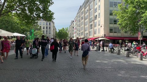 PARIS - CIRCA AUGUST, 2019: Footage of people walking and man riding scooter on street next to contemporary art museum called "Centre Pompidou" in Paris. It is a sunny summer day. Camera moves forward