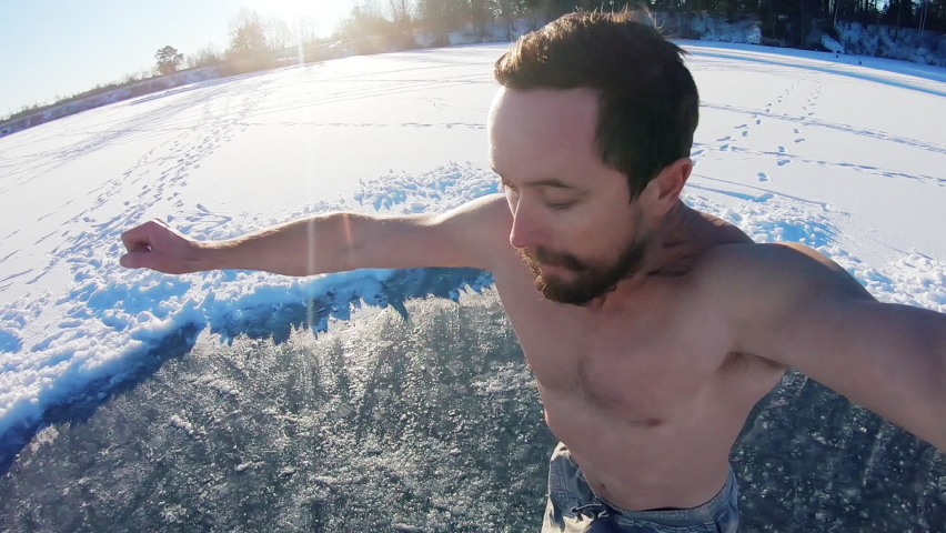 Winter swim. Young man jumps into winter lake at sunny day with forest on the background. Multi camera scene. Camera 3, POV Royalty-Free Stock Footage #1064177440