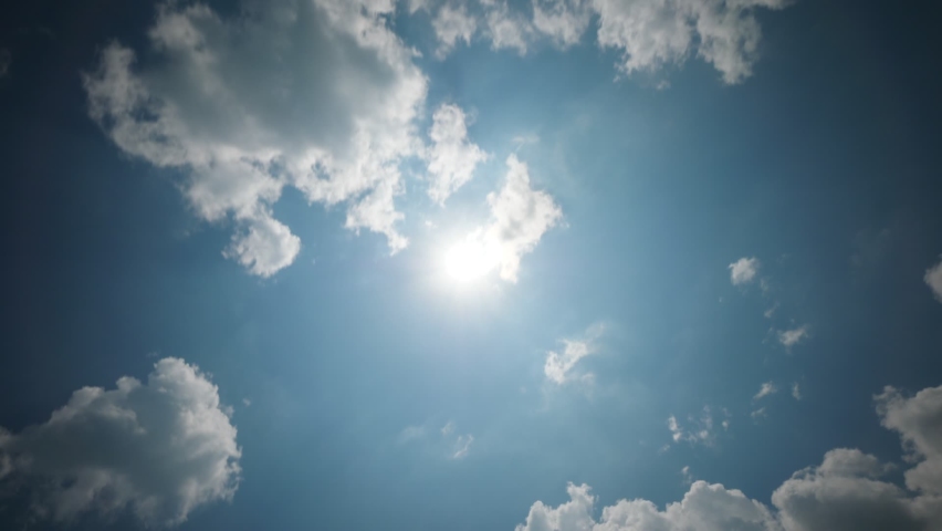 White clouds quickly fly against bright sun in Zenith, time lapse shot. Camera look straight up. White clouds wreath and curl, change shape while glide fast across skies Royalty-Free Stock Footage #1064205757