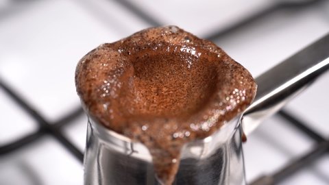 Boiling and overflowing coffee while preparation in turkish coffee pot