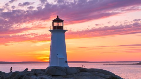Peggy's Cove Lighthouse at dusk Atlantic Coast Halifax Nova Scotia Canada. A Timelapse of the light house and dramatic clouds.