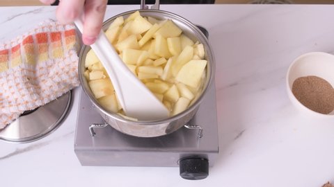 Boiling apples to make apple sauce on white marble side view