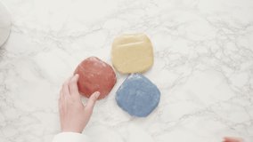Time lapse. Step by step. Flat lay. Rolling out dough with a rolling pin to bake red, white, and blue pinwheel sugar cookies.