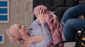 The woman with a turban in a wheelchair loves her newborn baby. Woman wearing a turban in a wheelchair who loves her baby.Video for the vertical story.