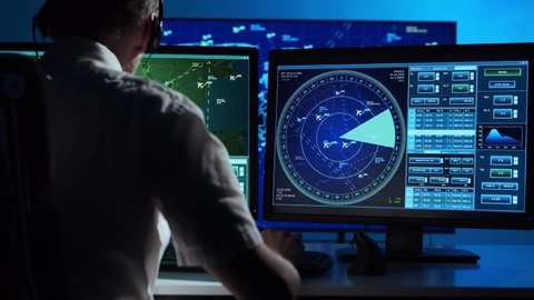 Workplace of the professional air traffic controller in the control tower. Caucasian aircraft control officer works using radar, computer navigation and digital maps.
