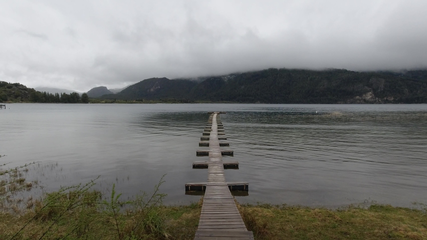Walking on wooden floating dock on the lake while it softly snows 