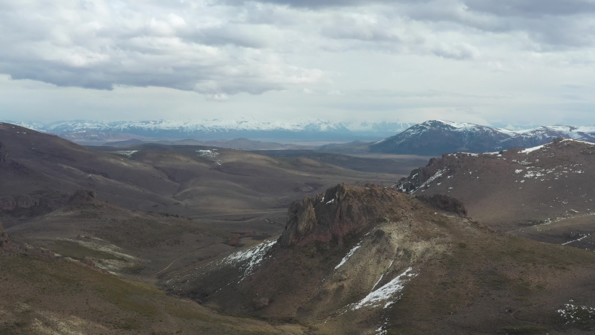 Drone aerial view of dirt road, mountains and rock formations in Patagonia Argentina
