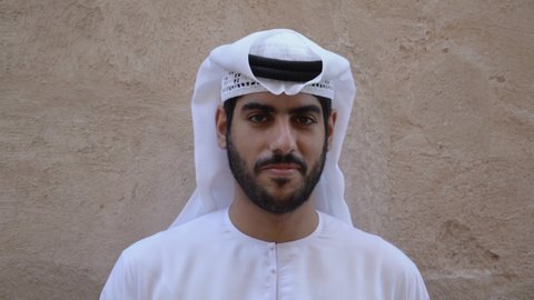 Local Emirati Arabic man looking wearing dish dash Kandora at the camera