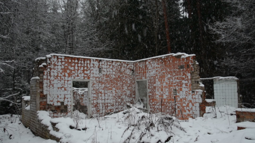 Ruins of a destroyed building in the forest in winter