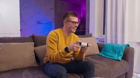 Excited man playing video games on modern console next gen 2020, new era of consoles, white gamepad, male at home play games