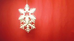 Wooden snowflakes filmed in flat lay on red background.Beautiful handmade decorations for winter holidays shot directly from above.Decorative snowflake figures cut from natural eco friendly wood