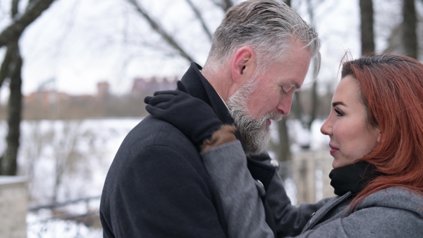 loving eyes and kisses of a young woman who spends time with her husband, an adult solid gray-haired man. Close-up hugs and kisses