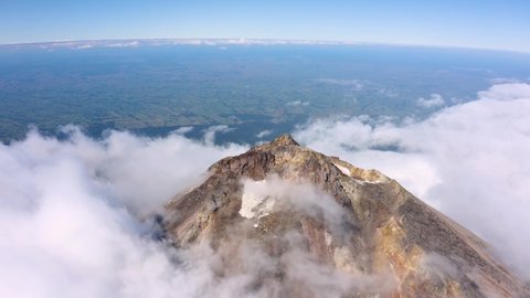 Volcano peak - dramatic drone aerial footage with cloud moving on the snowy peak of Mount Taranaki, Egmont National Park, New Zealand in 4k