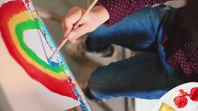 LGBTQ+ symbols. Rainbow paint on canvas in self-isolation close up. Boy artist holds brush uses blue paint. Creative manifestation of child in art lesson close-up.  - Powered by Shutterstock - Get 15% off with code: PIKWIZARD15
