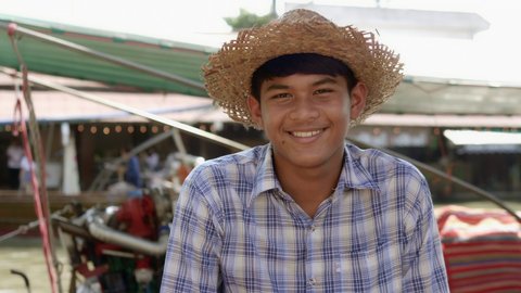 Tourist boat driver, smiling young Thai farmer, earning extra income on vacation, hiring tourists on a beautiful canal in Thailand.