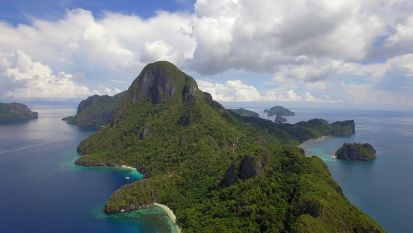 Aerial view of deserted tropical island near El Nido, Palawan, Philippines. El Nido is famous for its island hopping and snorkeling tours to secluded beaches and lagoons. Royalty-Free Stock Footage #1064305453