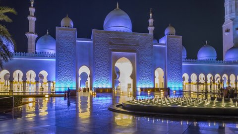 Sheikh Zayed Grand Mosque illuminated at night timelapse hyperlapse, Abu Dhabi, UAE. Front view with fountains. The 3rd largest mosque in the world