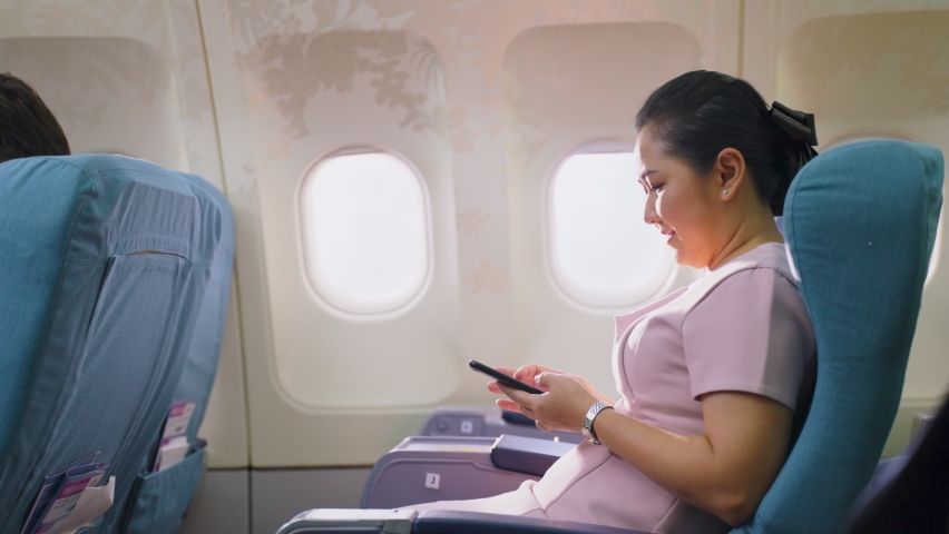 Onboard product purchasing, Asian woman sitting in airplane buying gift from air hostess and paying by credit card tapping on machine. Contactless payment and technology inflight service concept. Royalty-Free Stock Footage #1064310607