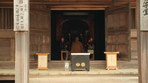 Buddhist Monk Praying Inside Wooden Temple