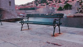 Close up empty bench view on sea channel and old town at sunset. Water historical ancient architecture boat building. Slow motion