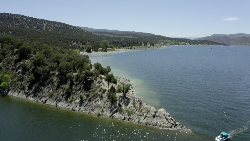 Aerial drone of people recreating, boating, swimming, camping, fishing at Rockport Reservoir in Summit County, Utah on a sunny, summer day.

