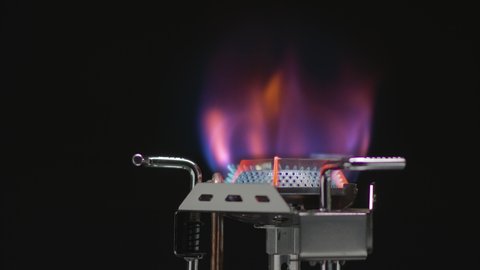 Bright Flame of a Gas Burner on a black background. Turning off the gas Cooker. The gas supply to the burner stops and the flame goes out, Red Hot Metal remains on a dark background.