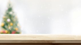 Numbers 2021 falling on wood table with snow and blurred Christmas tree in background for new year concept