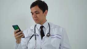 doctor uses the phone while sitting in the office