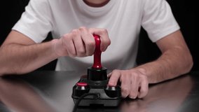 Young man using old fashioned joy stick playing on video game
