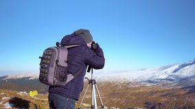 Photographer taking a picture in the cold mountains - Dolly shots