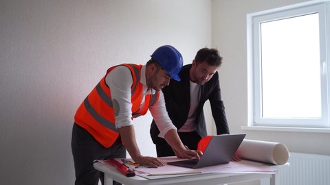 man contactor and entrepreneur using laptop.
Businessman and man architect browsing drafts on laptop while working on project in workplace together