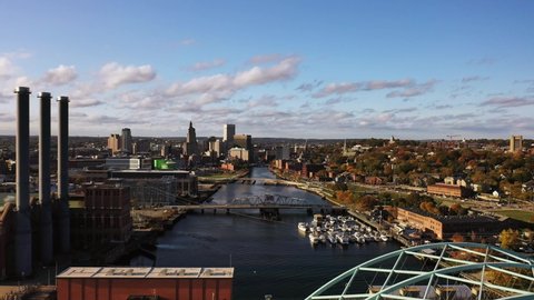 Aerial flying away from the downtown Providence, Rhode Island skyline with a traffic on a bridge crossing the river coming into view in the foreground below.