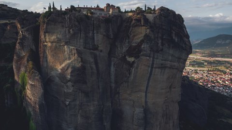 Aerial View of Meteora, Complex of Eastern Orthodox Monasteries, Greece pull up and reveal Holy Trinity Monastery in sun