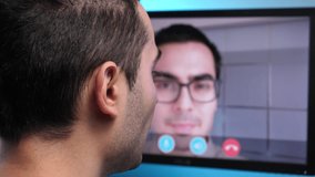 Video call on a computer monitor between two young men of the same age talking to each other using this technology.