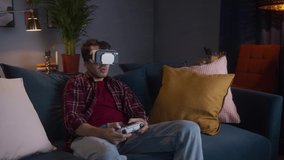 Asian man playing vr video games on console or phone with gamepad. Young student enjoying AR 3D video games on next gen, living room, virtual reality on isolation during coronavirus lockdown.
