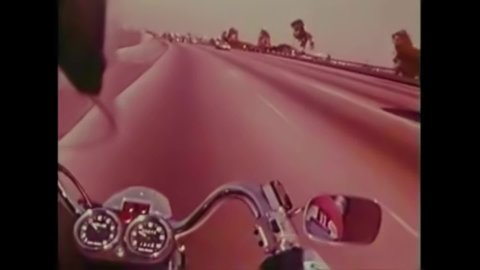 CIRCA 1970s - Peter Fonda rides away into the distance on his Harley Davidson motorcycle at the end of a 1973 film about motorcycle safety.