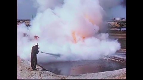 CIRCA 1950s - Scientists extinguish contained oil fires.